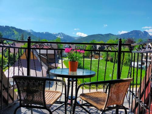 a table and two chairs on a balcony with mountains at Willa Paradna in Zakopane