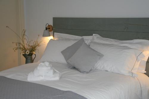 a white bed with white sheets and pillows at CASA AUTUNNO in Monzambano
