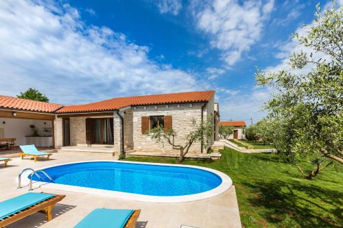 un patio trasero con piscina y una casa en Villa Vignola, en Kavran