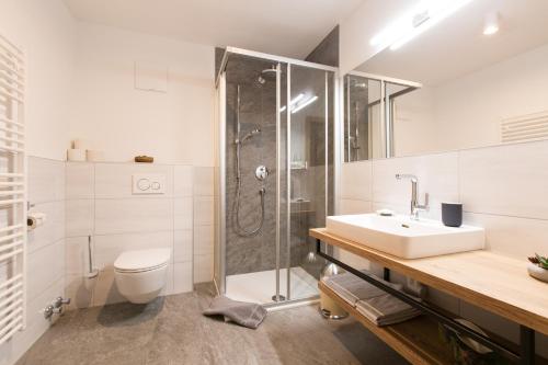 uma casa de banho com um chuveiro, um lavatório e um WC. em Apartment Wiesenhof - NATUR & WEITBLICK über Innsbruck - Ladestation für Elektroautos em Innsbruck