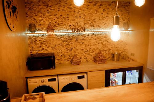 a kitchen with two washers and a counter with a counter at LE LOFT A BULLES (85m2 Jacuzzi Hammam Billiard Bar Douche Sauna) in Strasbourg
