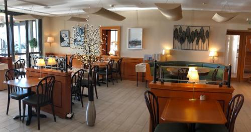 a dining room with tables and chairs in a restaurant at Hôtel du Port in Lausanne