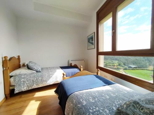 1 Schlafzimmer mit 2 Betten und einem großen Fenster in der Unterkunft Casa BellMón vive el Astroturismo en Belltall in Belltal