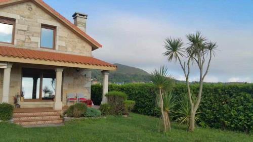 une maison avec un palmier dans la cour dans l'établissement Cubelas Porto do Son, à Porto do Son