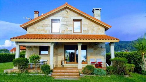a small stone house with a red roof at Cubelas Porto do Son in Porto do Son