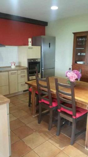 a kitchen with a wooden table with chairs and a refrigerator at Cubelas Porto do Son in Porto do Son