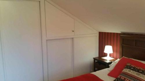 a bedroom with a bed and a white wall at Cubelas Porto do Son in Porto do Son