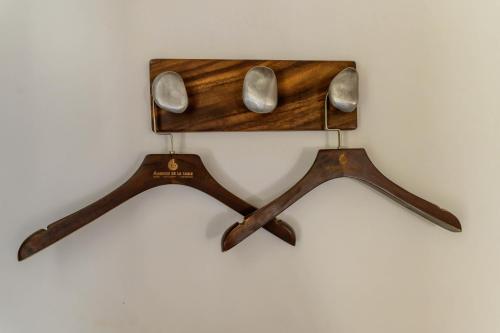 a pair of wooden spoons hanging on a wall at Auberge de la Table in Toliara