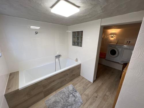 une salle de bain avec baignoire et machine à laver dans l'établissement 300 Jahre altes renoviertes Fachwerkhaus, à Peterslahr