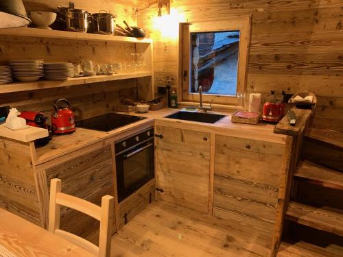 a kitchen with a stove and a sink in a cabin at Rascard Monterosa in Champoluc