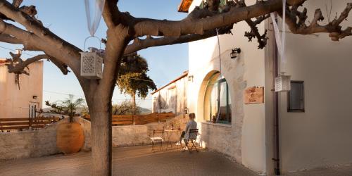 a person sitting in a chair next to a building at Villa Kirke with private swimming pool in Próvarma