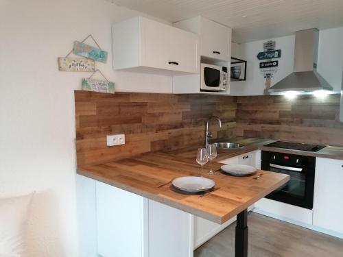 Una cocina con gabinetes blancos y una encimera de madera. en Esprit Mer classé - Wifi - Centre, en Auray