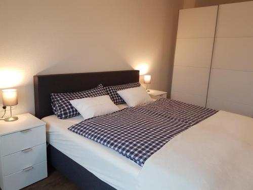 1 cama con manta a cuadros en blanco y negro en Ferienwohnung Quartier HOHE GEEST 12, en Cuxhaven
