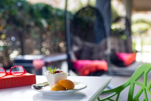 a plate of oranges on a table with a pair of glasses at Leonardo Boutique Hotel Tel Aviv in Tel Aviv