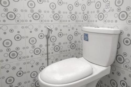 um WC branco numa casa de banho com uma parede em Nayla Homestay Jambi Mitra RedDoorz em Kayu Aro