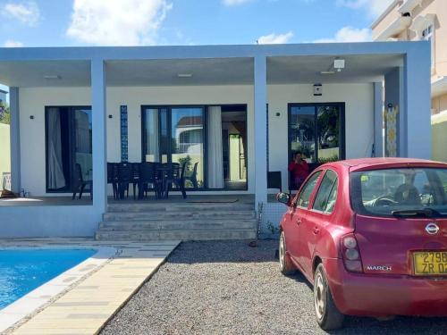 a red car parked in front of a house at Idyllic Villa in Pereybere with Private Pool in Pereybere