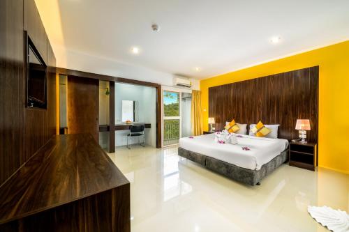 1 dormitorio con 1 cama grande y paredes amarillas en Naiyang Place - Phuket Airport en Nai Yang Beach