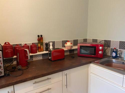 a kitchen counter with a microwave and a sink at Grace Stays in Ellesmere Port
