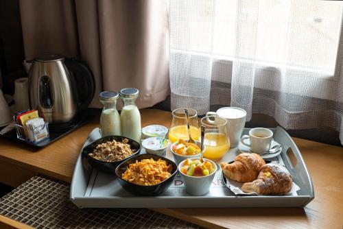 een dienblad met ontbijtproducten en drankjes op een tafel bij Ara di Marte Suites in Rome
