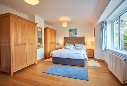 a bedroom with a bed and a large window at Seawynds in Port Isaac