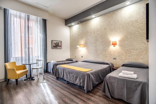 Habitación con 3 camas, mesa y silla en Hotel Seiler, en Roma