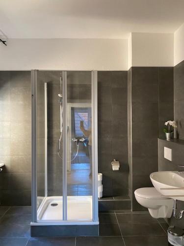 ein Bad mit einer Dusche, einem WC und einem Waschbecken in der Unterkunft Gästehaus Windheim Ettlingen Stadt in Ettlingen