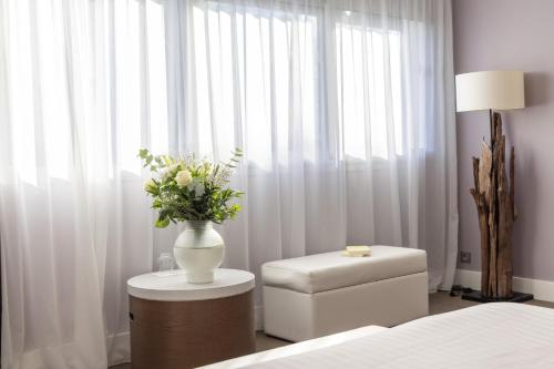 a bedroom with a vase of flowers on a table at Hôtel Château des Tourelles - Relais Thalasso & Spa in Pornichet