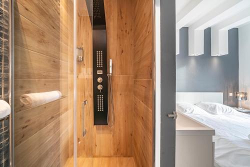 a bathroom with a shower with a wooden door at Frontière Monaco, Appartement Rénové Entièrement - AG in Beausoleil