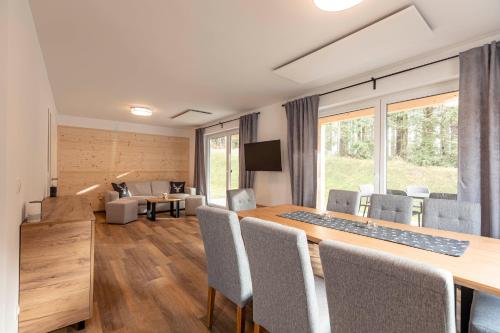 un comedor con una mesa larga y sillas en Englmar Chalets by ALPS RESORTS, en Sankt Englmar