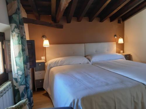 a bedroom with a large bed with two white pillows at Casas Recuero in Chinchón