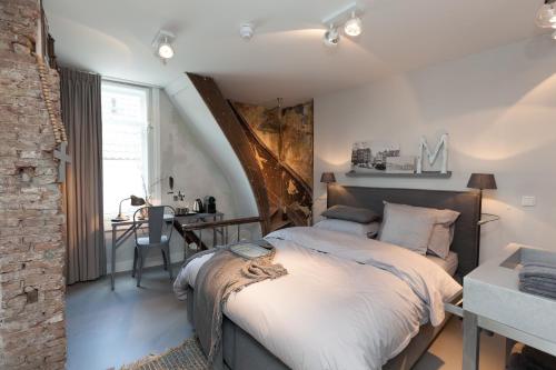 a bedroom with a large bed and a table at Mother Goose Hotel in Utrecht