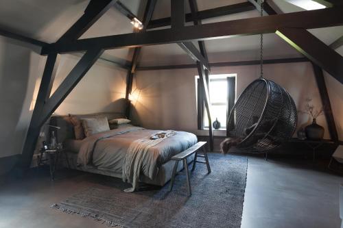 a bedroom with a bed and a hanging chair at Mother Goose Hotel in Utrecht