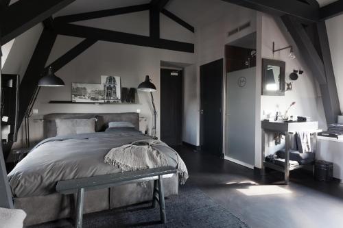 a bedroom with a large bed and a sink at Mother Goose Hotel in Utrecht