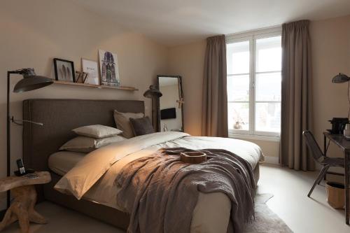 a bedroom with a large bed and a window at Mother Goose Hotel in Utrecht