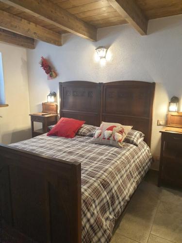 a bedroom with a large bed with a wooden headboard at Antica casa occitana in Sampeyre