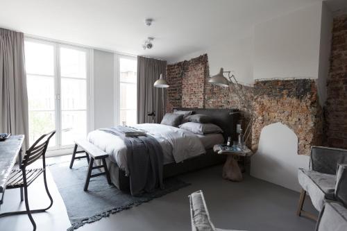 a bedroom with a bed and a brick wall at Mother Goose Hotel in Utrecht