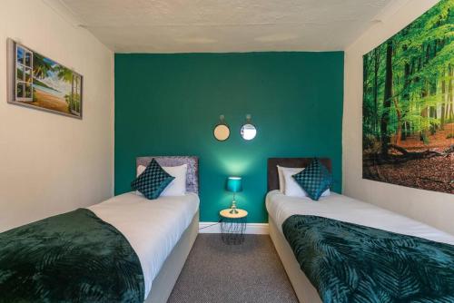 2 łóżka w pokoju z zielonymi ścianami w obiekcie The Miracle Spacious 2 Bedroom 3 Beds Central Hull w mieście Hull