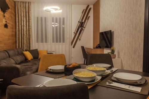 a living room with a table with bowls of food on it at Modern Mountain - Apartman 401 in Kolašin