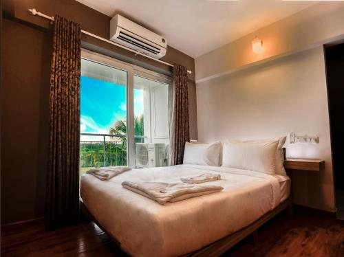 a bedroom with a large bed and a window at Transit Suites by GrandWest in Nedumbassery