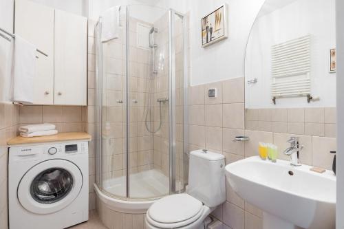 een badkamer met een douche, een toilet en een wastafel bij Metro Młynów Pleasant Apartament in Warschau
