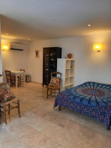 une chambre avec un lit, une table et des chaises dans l'établissement Studios Domaine l'Oliveraie, au Castellet