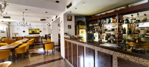 5 Stars High Hostel في بوخارست: مطعم فيه بار بالكراسي الصفراء