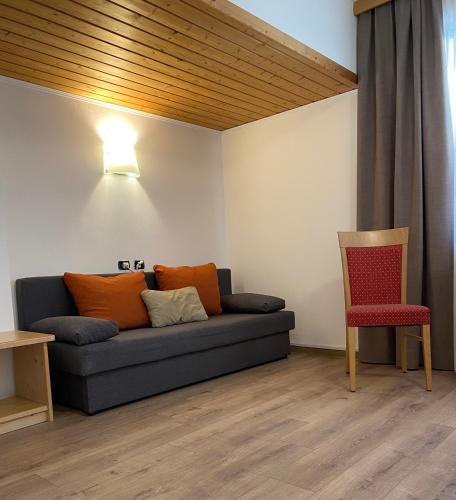 a living room with a couch and a chair at Hotel Garni LIVING in San Candido