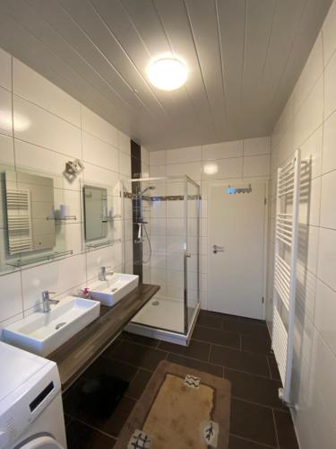 a bathroom with two sinks and a shower at L1 Apartments in Neunkirchen