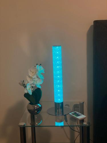 a blue vase on a glass table with a remote control at L1 Apartments in Neunkirchen