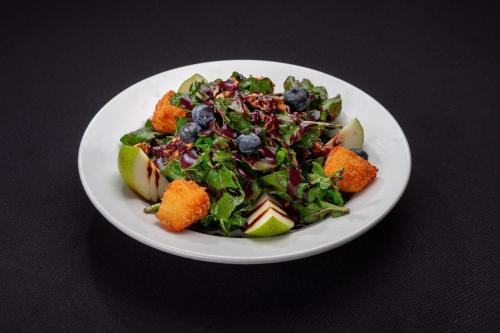 a white plate of food with a salad on a table at InterContinental Costa Rica at Multiplaza Mall by IHG in San José