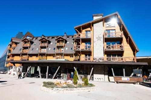 ein großes Holzgebäude, vor dem Menschen entlanggehen in der Unterkunft Apartman 107 - Aparthotel Vučko Jahorina - private host in Jahorina