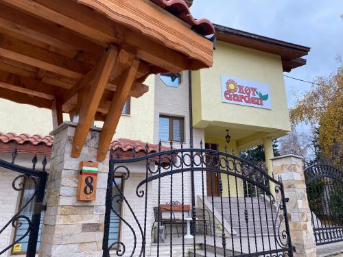 a gate in front of a building with a restaurant at Kot Garden Guest House in Sapareva Banya