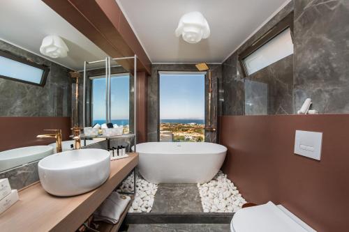 baño con bañera grande y ventana grande en Onira Suite Dreams en Hersonissos