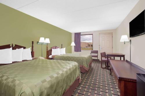 a hotel room with two beds and a flat screen tv at Days Inn by Wyndham Eufaula AL in Eufaula
